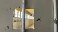 باب حديدي تطل نافذته الصغيرة على غرفة في سجن صيدنايا