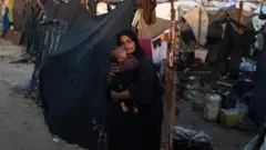 أم فلسطينية مع ابنها في غزة
