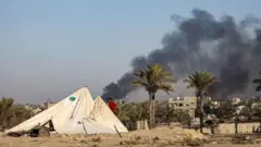 ستون‌های دود سیاه در روز دوشنبه در شهر دیرالبلح در غزه 