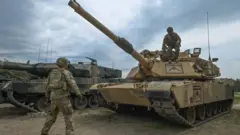 กองทัพสหรัฐฯ ยืนอยู่ข้างรถถัง M1A2 เอบรามส์ระหว่างการซ้อมรบกับกองทัพโปแลนด์