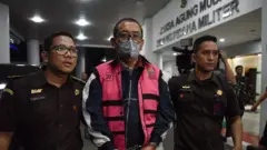 Tian Bahtiar Direktur pemberitaan Jak TV menjadi tersangka dan sedang dikawal petugas kejaksaan agung. 