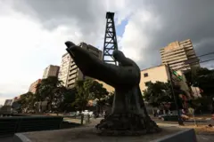 Escultura de mão saindo de poço de petróleo na Venezuela