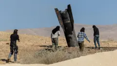 İsrail işgali altındaki Batı Şeria'ya düşen bir İran füzesi ve İsrailli yerleşimciler görülüyor.