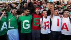 Un groupe d'hommes portant des T-shirts avec des lettres épelant le nom de l'Algérie lors d'une manifestation en 2019.