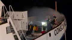 Bombeiros tentam apagar o fogo a bordo do navio Conscience, da Frota da Liberdade por Gaza