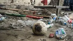Un balón de fútbol chamuscado se ve entre los escombros del incidente.