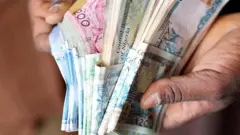 Umugabo urimo kubara amafaranga muri Nigeria