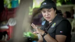 Auditora fiscal do trabalho, com uniforme, dá orientações a servidores públicos em uma pedreira e conversa com trabalhadores resgatados