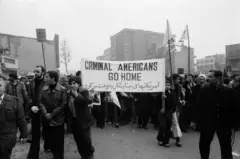 Manifestantes carregam uma faixa com os dizeres "Criminosos americanos, voltem para casa" durante os protestos do Dia da Ashura em Teerã durante a Revolução Iraniana, em 11 de dezembro de 1978.