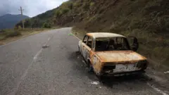 Брошенный автомобиль, оставленный бежавшими армянами, на обочине дороги, ведущей к Лачинскому коридору. Фото сделано 3 октября 2023 года во время поездки представителей СМИ, организованной правительством Азербайджана 