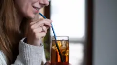 Mujer bebiendo un refresco frío