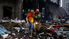 Душанба тонгидаги ҳужумлардан сўнг Киевдаги қутқарув хизматлари бомба зарбасига учраган бинолар вайроналари орасидан тирик қолганларни қидириб, эвакуация қилмоқда.
