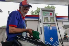Un empleado llena el tanque de una moto mientras se exhiben los precios del combustible, recién aumentados, en una estación de servicio de Hindustan Petroleum en Srinagar, Jammu y Cachemira, el 25 de mayo de 2026.