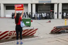 Mujer con un cartel que dice "Educación y no deportación".