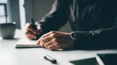 በእስክቢርቶ የሚጽፍ ግለሰብ እጅ