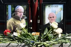 Yadda ake ajiye furanni a gaban hotunan Yevgeny Prigozhin da 'wazirinsa' Dmitry Utkin a gaban ofishin kamfanin mayaƙan Wagner da ke Rasha a ranar Alhamis
