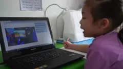 تلميذة تدرس عبر الإنترنت عبر الكمبيوتر المحمول في المنزل في 19 مايو/أيار 2020 في نونثابوري ، تايلاند
