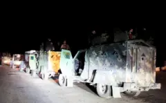 قوات سورية تستقل مركبات عسكرية في طريقها إلى اللاذقية ليلاً.