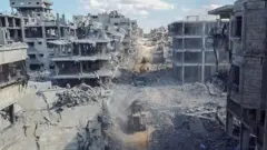 На снимке с дрона видно, как тяжелая техника работает вокруг разрушенного жилого квартала после вывода израильских войск из этого района на фоне прекращения огня между Израилем и ХАМАС в Газе,18 октября 2025 года.