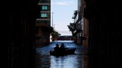 Pessoas num barco numa rua inundada de Porto Alegre