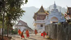 Monges andam junto aos templos de Luang Prabang, no Laos