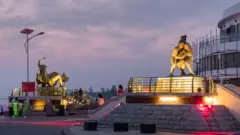 ကုလားတန်မြစ်ဘေး စစ်တွေမြို့ ကမ်းနား ဗျူးပွိုင့်ကို လာရောက်လည်ပတ်သူ တချို့နဲ့ ကမ်းနားမှာရှိတဲ့ ရုပ်တု ၂ ခု 