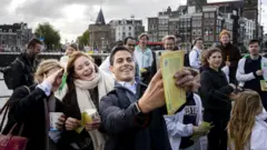 Jetten sonríe al tomarse una foto con un grupo de personas al aire libre