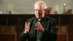 Justin Welby wearing a black blazer, glasses and clerical collar