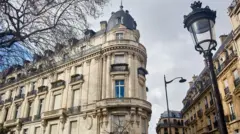 Vista exterior del edificio en la Avenida Foch donde se encontraba el apartamento de Epstein, que muestra un imponente edificio de piedra con una cúpula en la esquina.