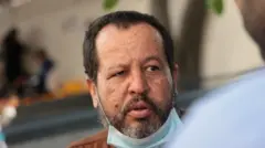 Alí Rodríguez con un gesto preocupado y cansado y una mascarilla azul.