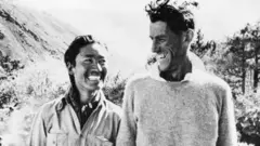 டென்சிங் நோர்கே (அப்போது 39) மற்றும் எட்மண்ட் ஹிலாரி (33) எவரெஸ்ட் சிகரத்தின் வரலாற்றுச் சிறப்புமிக்க ஏறிச் சென்ற சிறிது நேரத்திலேயே எடுக்கப்பட்ட புகைப்படத்தில்