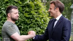 Perezida wa Ukraine Volodymyr Zelensky (ibumoso) na Perezida w'Ubufaransa Emmanuel Macron basuhuzanya nyuma yo gutanga ikiganiro n'abanyamakuru mu murwa mukuru Kyiv wa Ukraine, ku itariki ya 16 y'uku kwezi kwa gatandatu mu 2022.