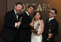 Quatro pessoas segurando estatuetas do Oscar