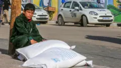 गाजामा संयुक्त राष्ट्रसङ्घले उपलब्ध गराएको खाद्यान्न लिँदै एक बालक 