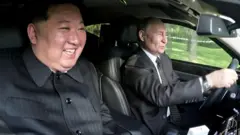 Kim Jong Un e Vladimir Putin, sorrindo e dirigindo juntos em um automóvel, em Pyongyang, no último mês de junho, com as mãos de Putin ao volante