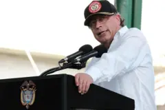 imagen del presidente gustavo petro. está frente a un podio y viste una camisa blanca.