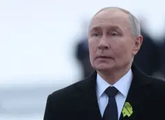 Vladímir Putin, con traje oscuro y un pequeño lazo amarillo en la solapa.