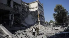 Dois homens caminham em meio a destroços causados por ataque de Israel a Damasco, a Síria, em 16/7/2025