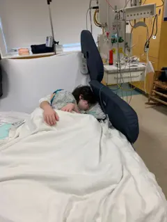 Uma criança deitada em uma cama de hospital