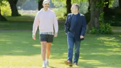 Luke e Alastair caminhando em parque