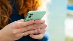 O femeie verificându-și telefonul.