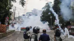 রাস্তায় টিয়ার শেলের ধোঁয়া, ব্যারিকেড ফেলা। দাঁড়িয়ে আছেন আইনশৃঙ্খলা বাহিনীর চারজন সদস্য