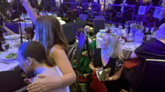 Pessoas se abaixam durante o jantar