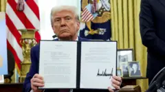 Trump mostra documento com assinatura de medidas executivas no dia de sua posse