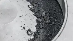 실험실 용기에 담긴 검은색 가루