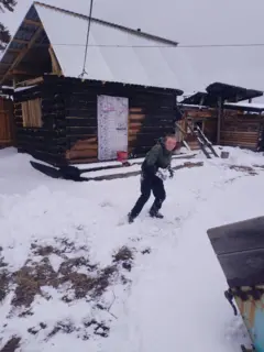 Vova brincando no terreno de uma casa coberto de neve