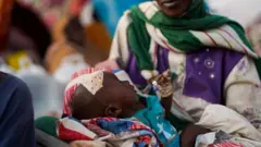 حفيدة إكرام عبد الحميد المصابة تنظر إلى مخيم للنازحين الذين فروا من الفاشر إلى طويلة، شمال دارفور، السودان.