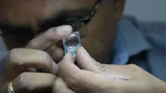 हिऱ्याची पारख करताना व्यापारी 