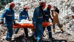 Спасатели на руинах разрушенного здания после российского удара