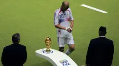 Zinedine Zidane passa pelo troféu da Copa do Mundo, depois de ser expulso contra a Itália